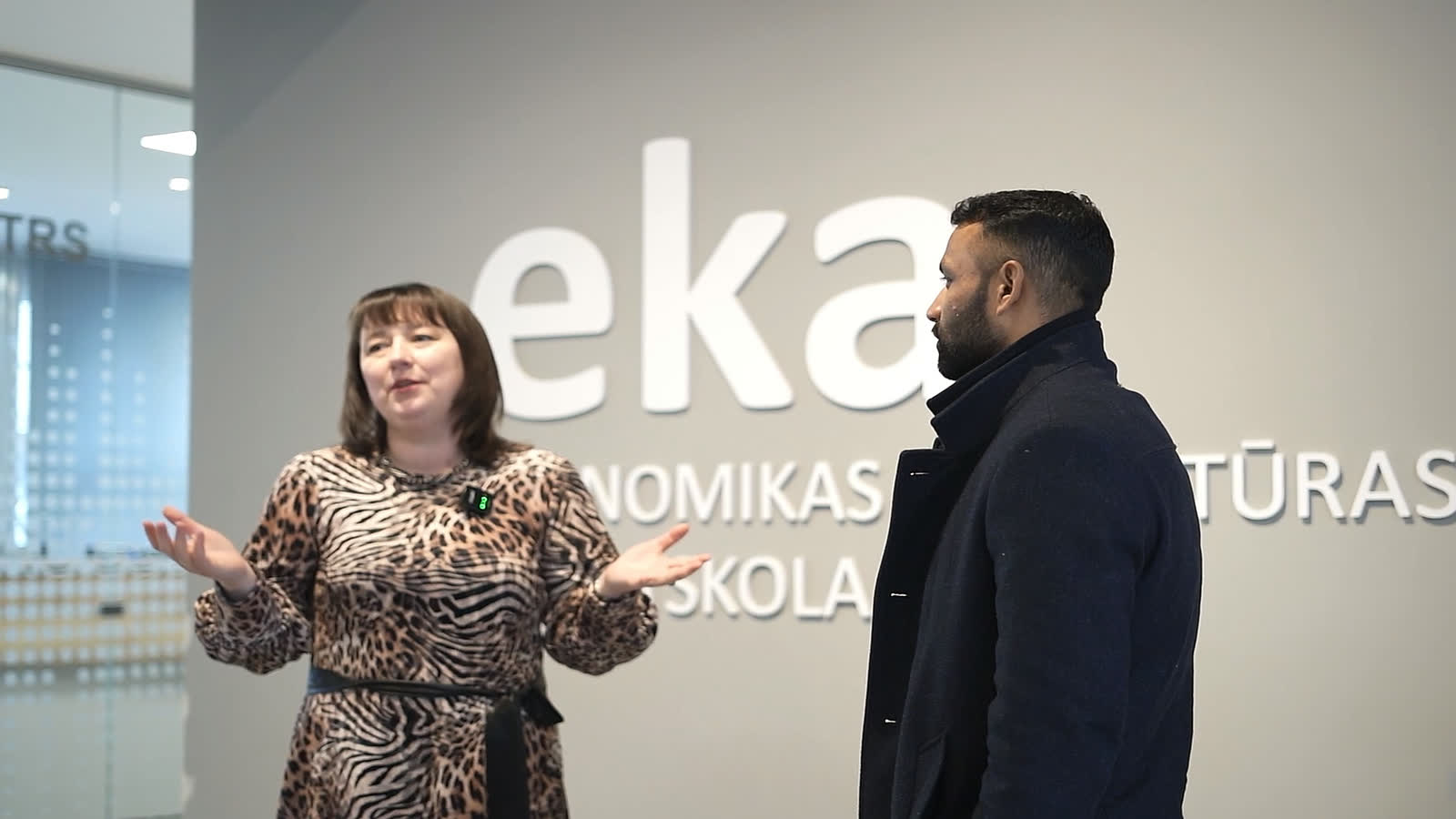 An EKA representative gesturing mid-explanation beside our CEO, in front of the “eka” lettering in the entrance hall